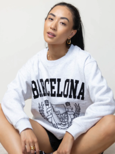 woman sitting down and wearing a barcelona hoodie