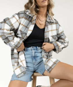 woman on a stool while wearing a plaid jacket and mini denim shorts